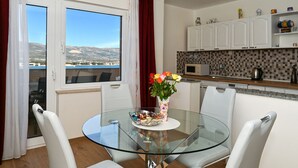 A modern kitchen with white cabinets, a microwave, and a tiled backsplash. - Radelic, comfortable two bedroom apartment (Mastrinka)