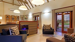 A modern living room with a fireplace, sofas, and a view of the outdoors.