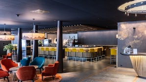 Un hall d’entrée moderne doté d’un bar, d’espaces aménagés pour s’asseoir et d’un mur décoratif.