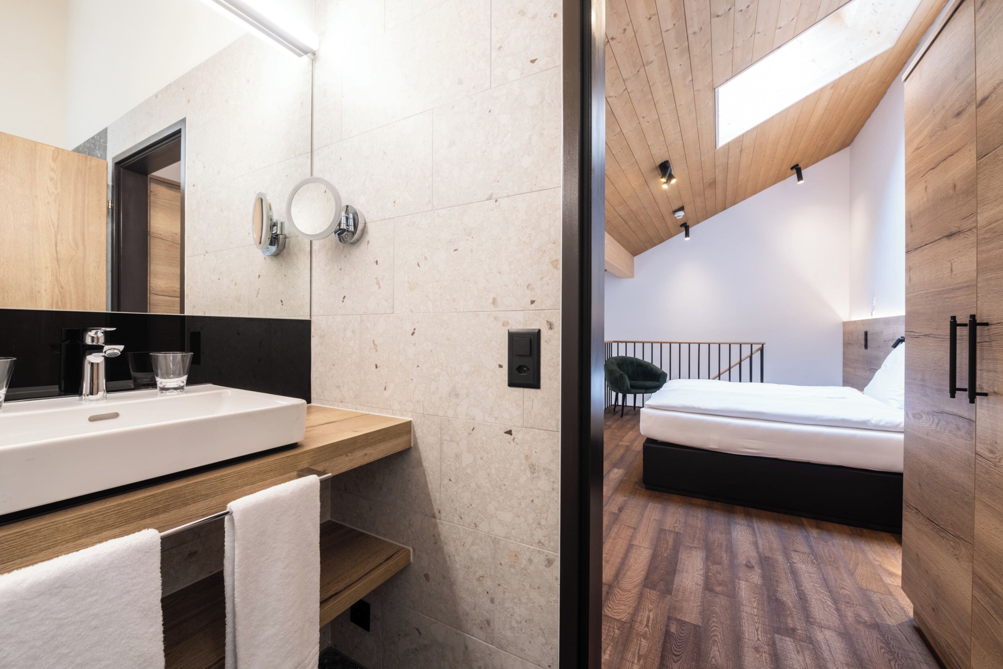 A modern bedroom with a wooden ceiling, a large bed, and a wooden floor.