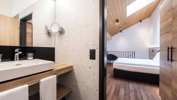 A modern bedroom with a wooden ceiling, a large bed, and a wooden floor.