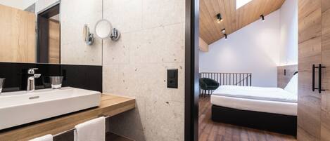 Un dormitorio moderno con techo de madera, una cama grande y piso de madera.
