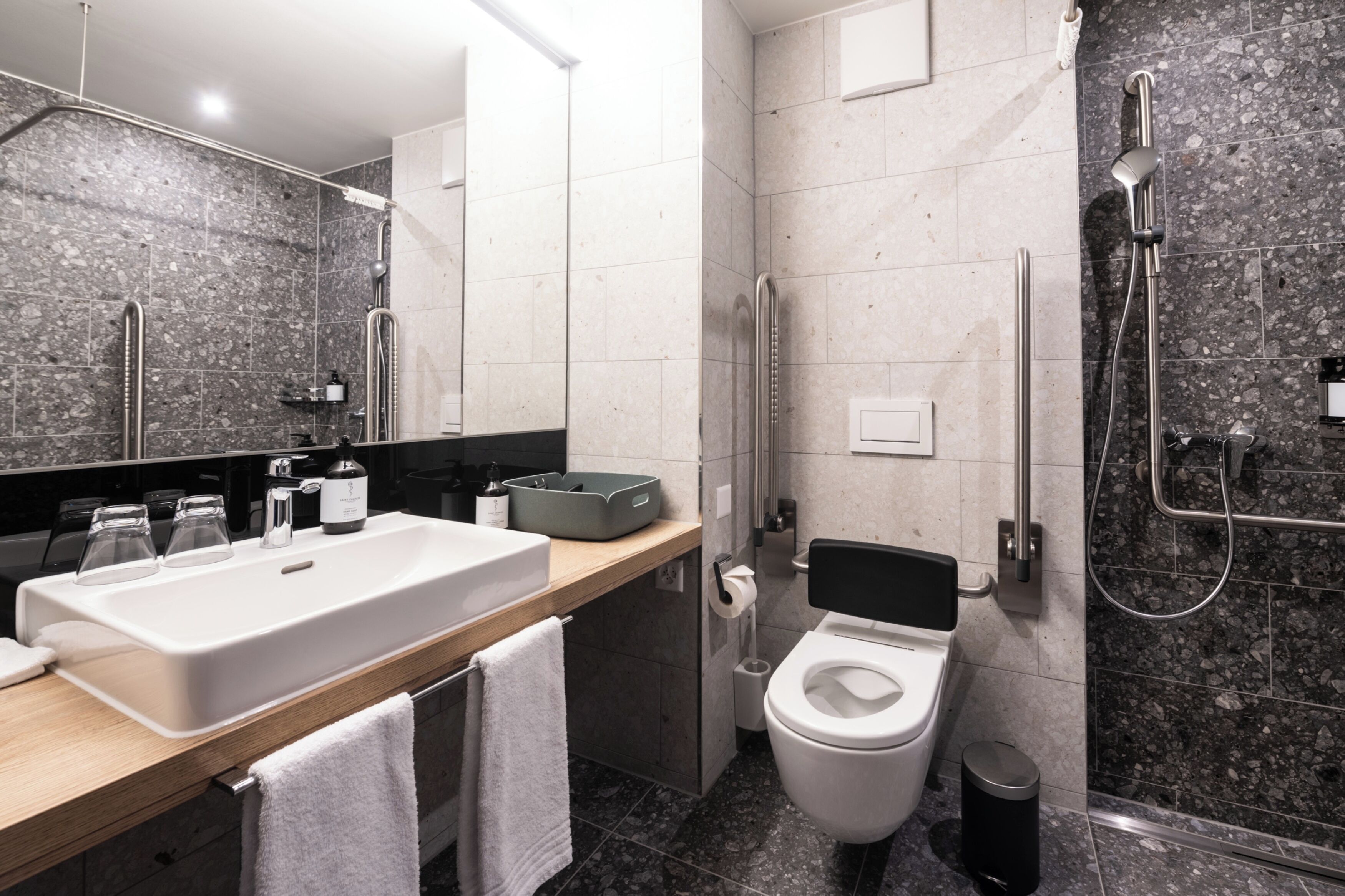 Un baño moderno con un lavamanos grande, inodoro y ducha.