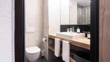 A modern bathroom with a toilet, sink, and shower.