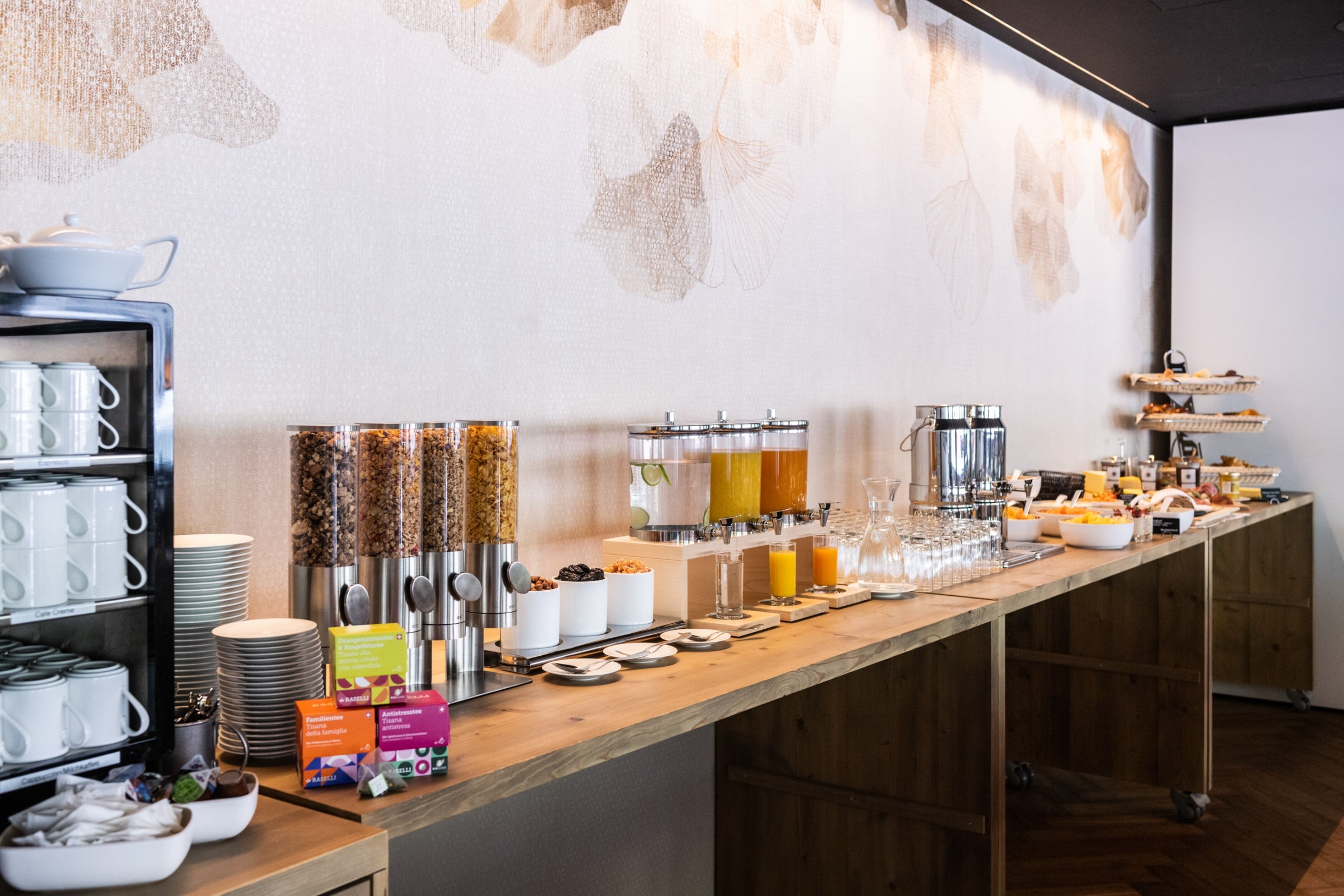A buffet setup with various food and drink options, including cereal, fruits, and beverages.