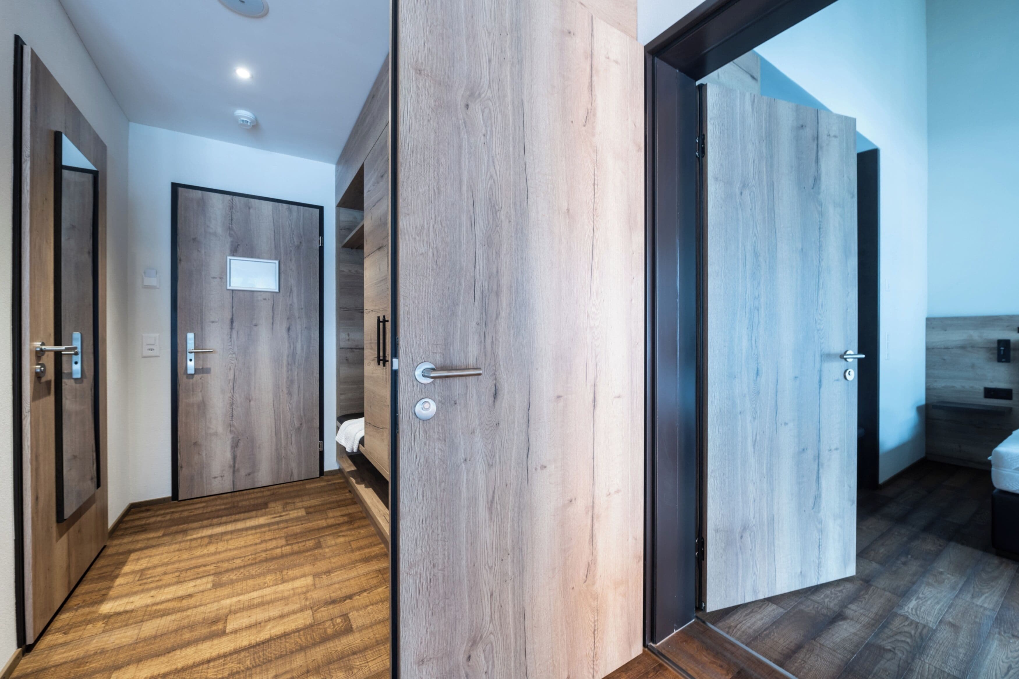 Un couloir avec des portes en bois et un plancher en bois.