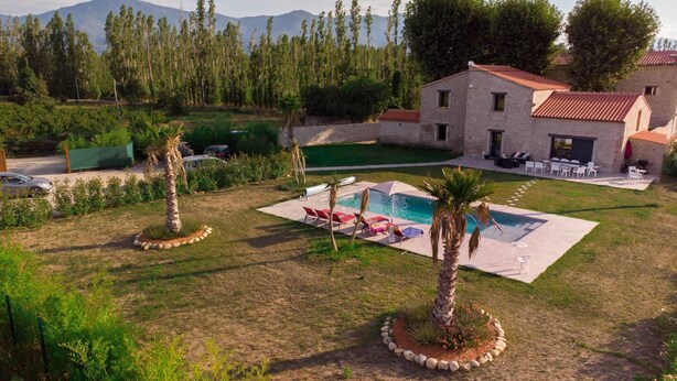 Une villa avec piscine, espace extérieur aménagé et vue sur les montagnes.