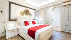 Un dormitorio moderno con una cama grande, una mesita de noche, un espejo y una lámpara de techo.