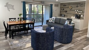 Una sala moderna con una mesa de comedor, sofá y sillones azules.