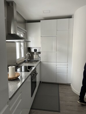 Eine moderne Küche mit Edelstahlgeräten, einer Granit Arbeitsplatte und weißen Schränken.