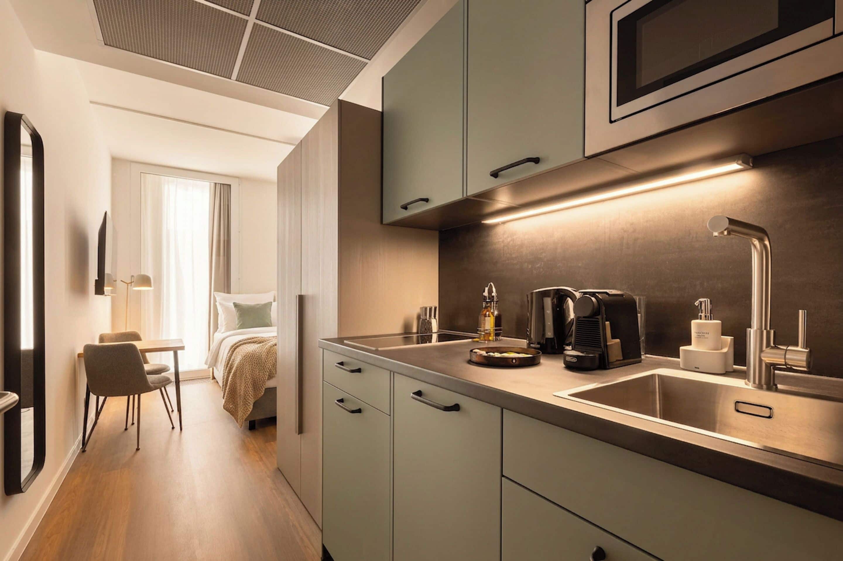 Eine moderne Küche mit Einbau-Mikrowelle, Kaffeemaschine und Spüle.