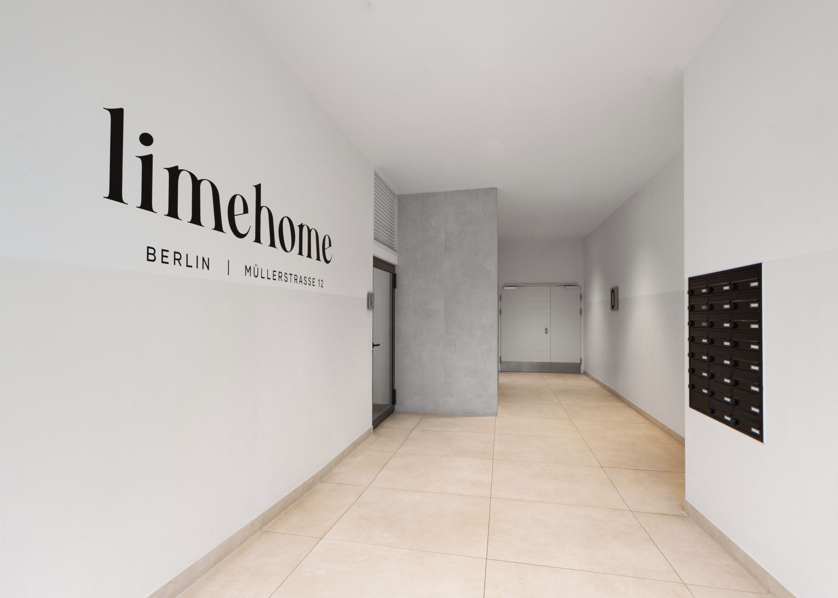 A hallway with a sign reading 'limehome BERLIN | MÜLLERSTRASSE 12'.