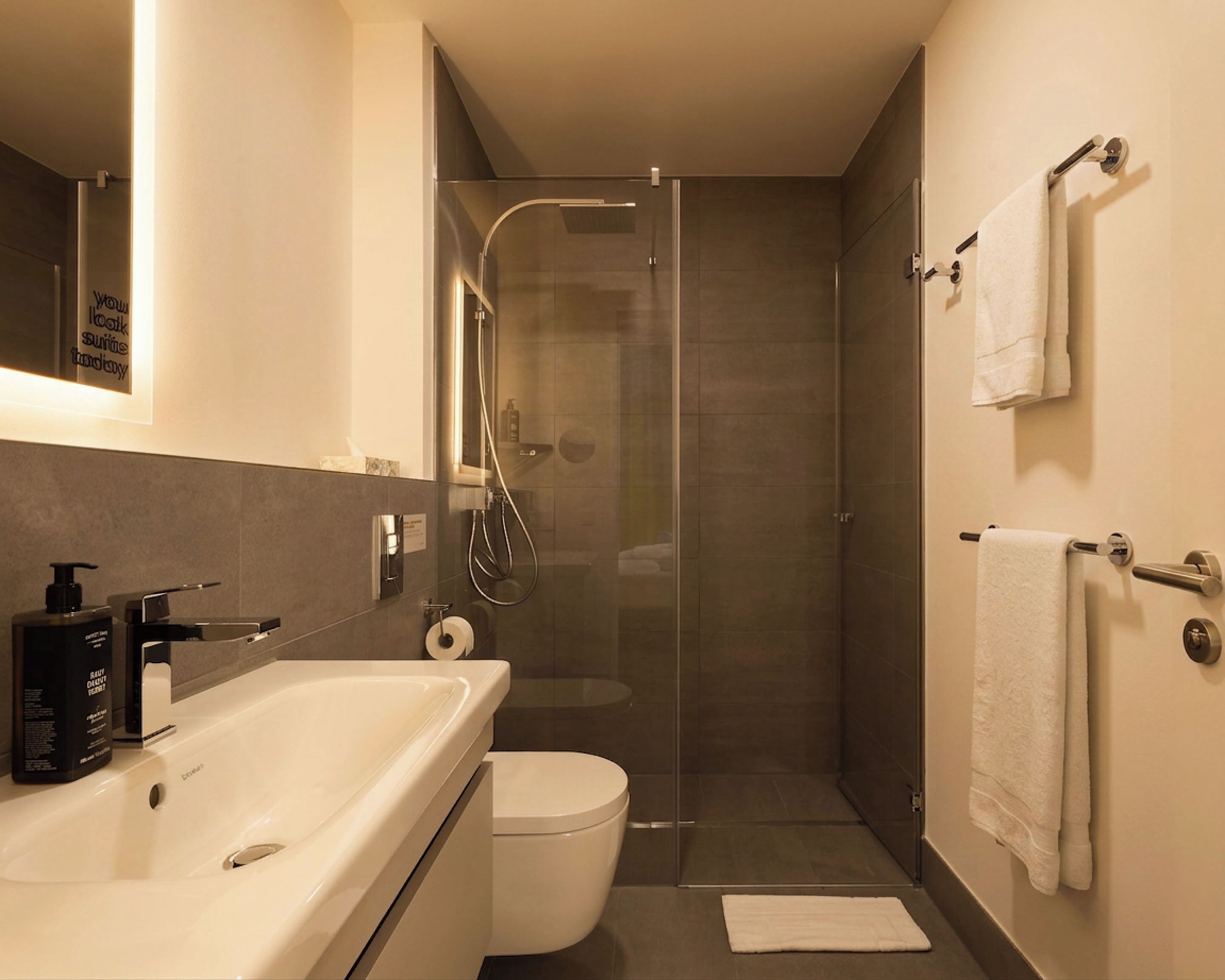 Et moderne badeværelse med badekar, toilet og bruser.