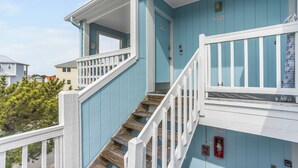 Un immeuble à plusieurs étages, avec une façade bleue et des balustrades blanches.
