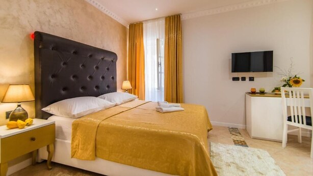 A hotel room with a bed, a desk, a TV, and a chair. - BELLA NATKA BED AND BREAKFAST (Rovinj)