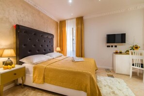 A hotel room with a bed, a desk, a TV, and a chair.