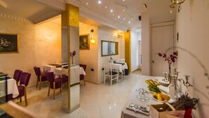 A dining area with white tables and purple chairs, a chandelier, and a mirror on the wall. - BELLA NATKA BED AND BREAKFAST (Rovinj)