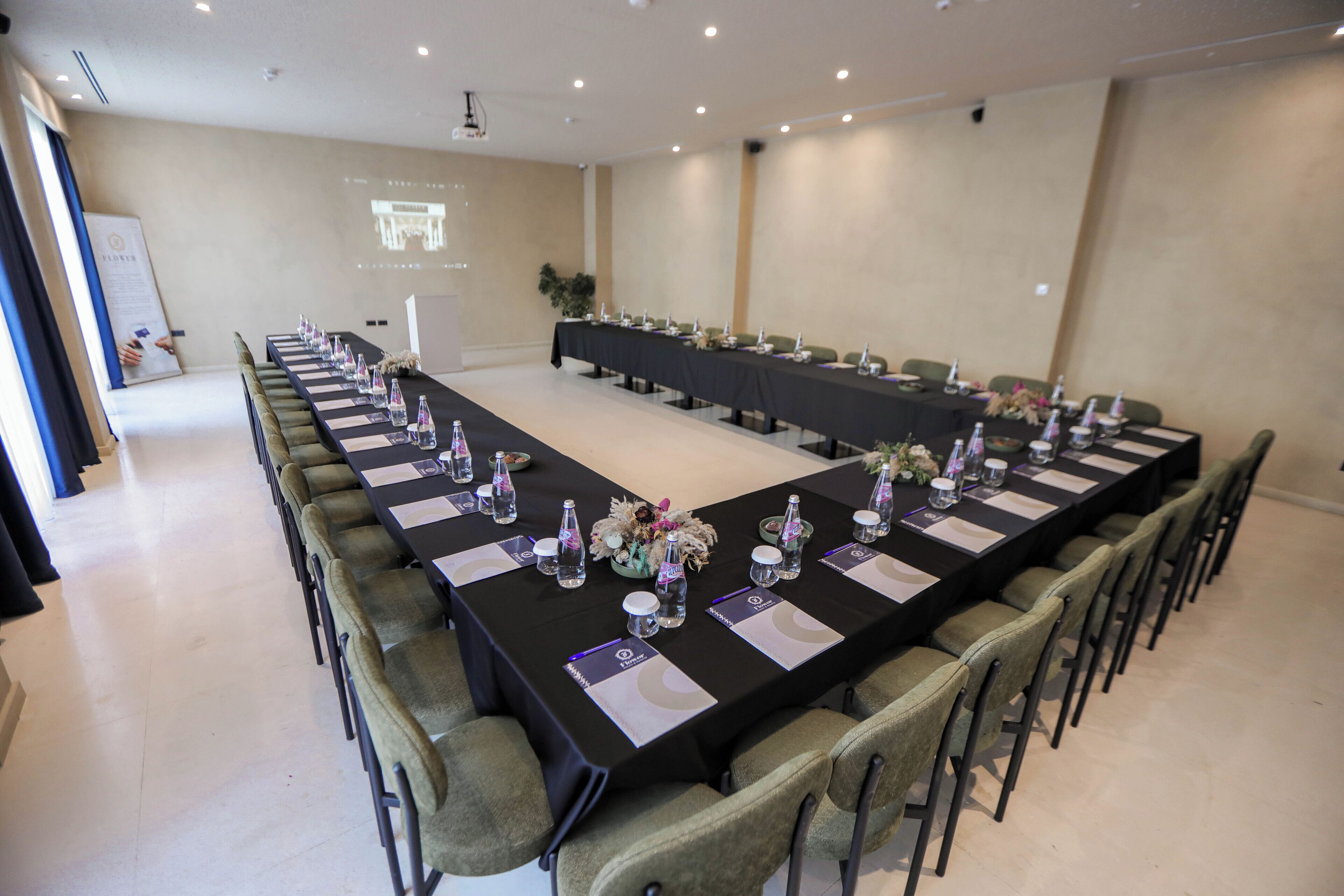 Une salle de conférence équipée d’une longue table, de chaises et d’un écran de projection.