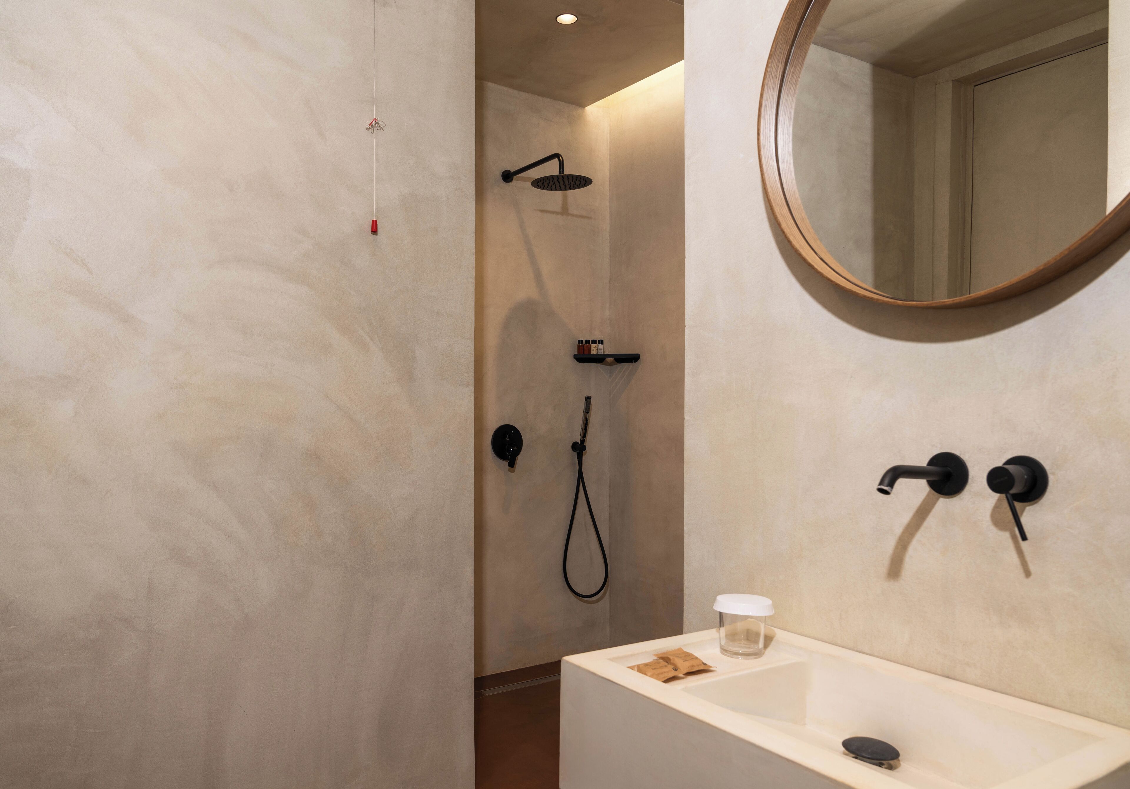 A bathroom with a shower, a sink, and a mirror.