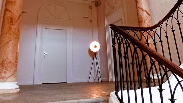 A staircase with marble columns, a black metal railing, and a white door at the top. - Apartment (Conqueyrac)