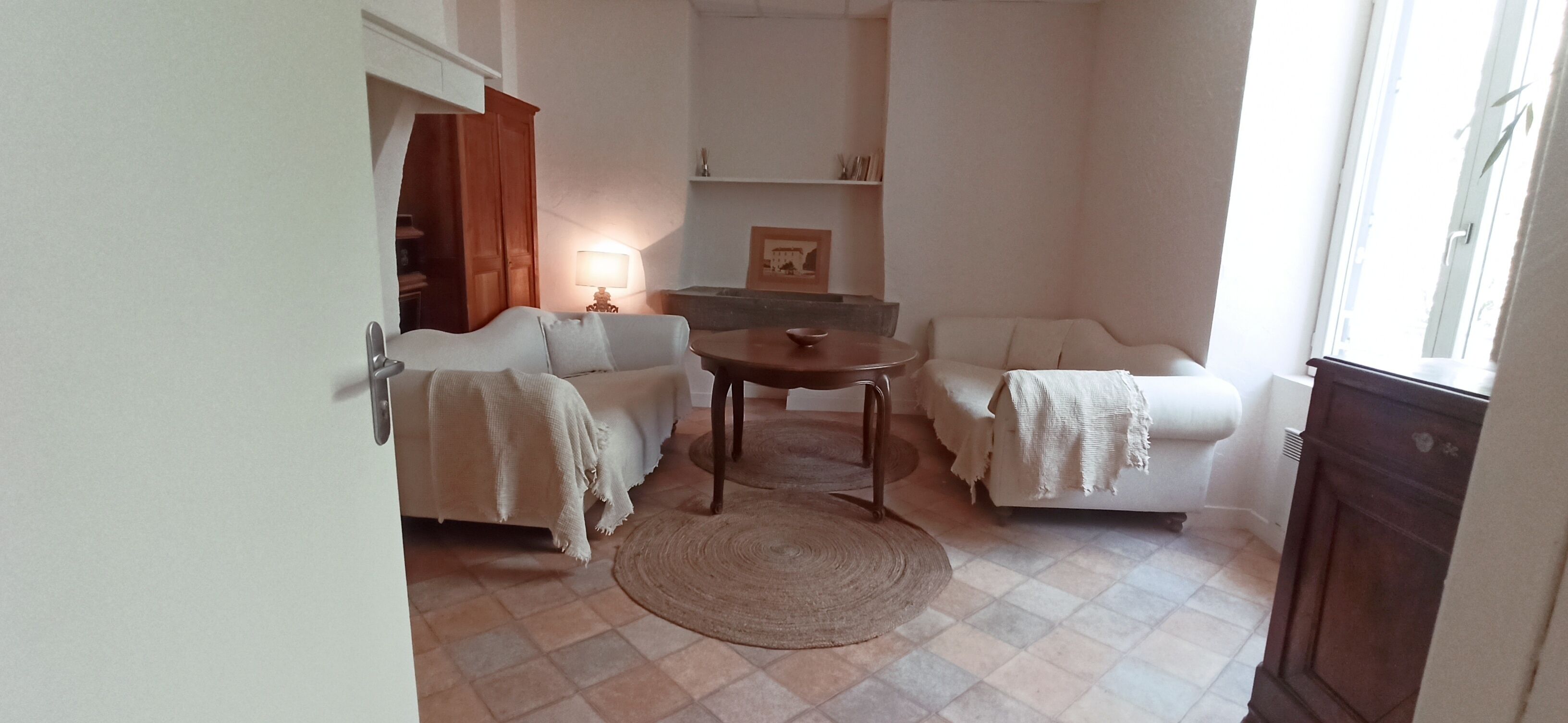 Un salon confortable avec un canapé, une petite table et une lampe.