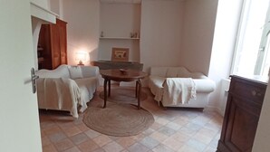 A cozy living room with a sofa, a small table, and a lamp. - Apartment (Conqueyrac)