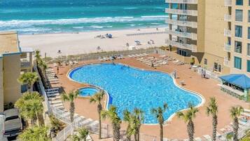 A hotel with a pool, beach access, and a view of the ocean.