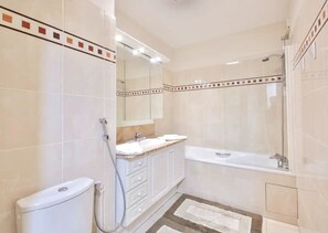 Tina, secadora de cabello, toallas, papel de baño