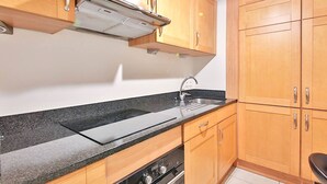Una cucina con mobili in legno, un lavello in acciaio inossidabile e un forno integrato.
