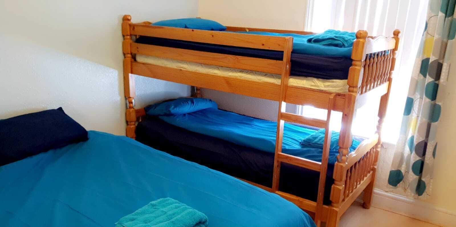 Un lit superposé avec une literie et des oreillers bleus.
