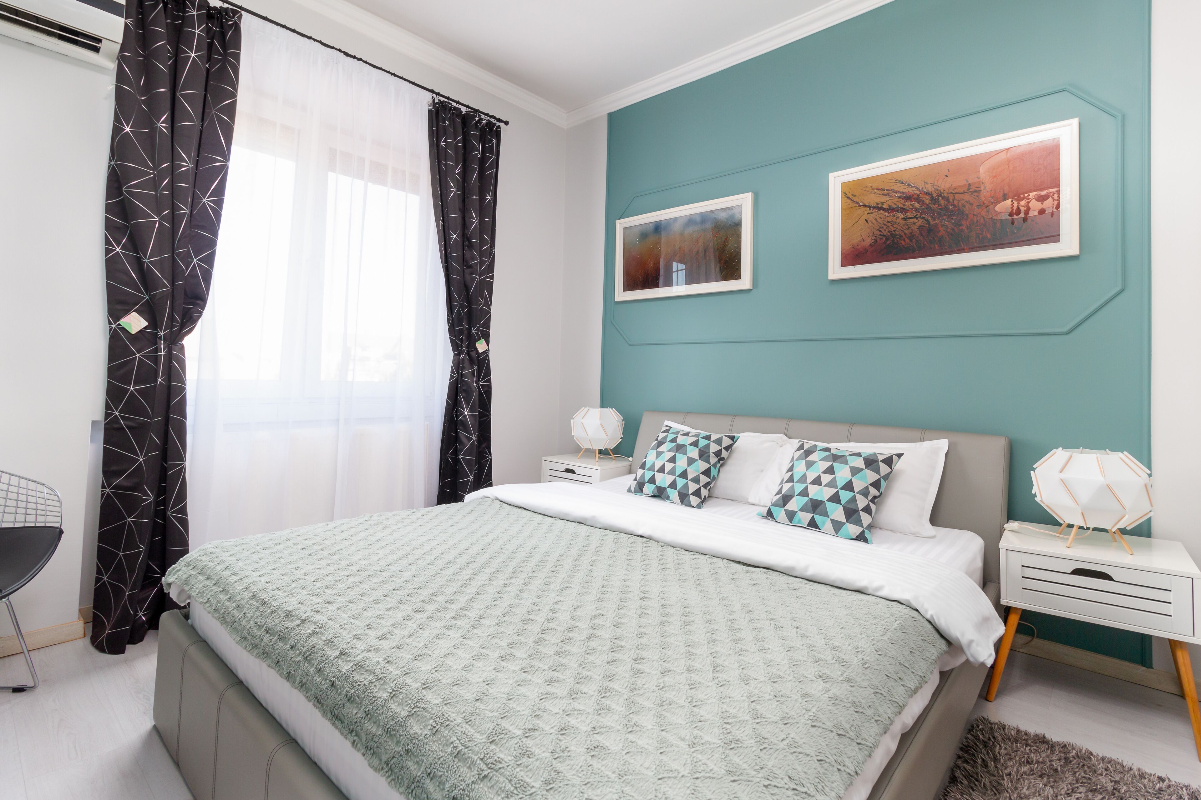 Un dormitorio moderno con cama, mesitas de noche y un escritorio.