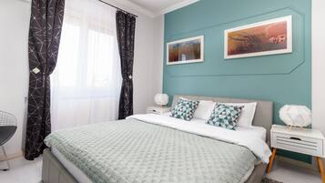 Un dormitorio moderno con cama, mesitas de noche y un escritorio.
