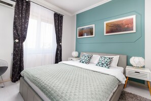 Um quarto moderno com uma cama, mesas de cabeceira e uma escrivaninha.