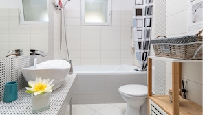 Ein modernes Badezimmer mit einer freistehenden Badewanne, einer Toilette und einer Duschkabine.