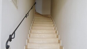 Una escalera con peldaños color crema y barandilla negra.