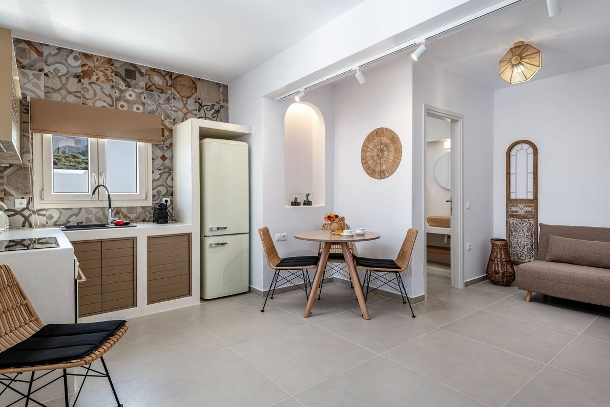 Una cocina moderna con ventana, un comedor con mesa y sillas, y una sala de estar con sofá.