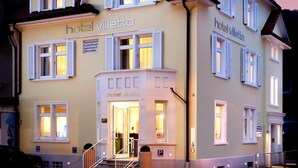 A hotel with a classic European architectural style, featuring a symmetrical facade, multiple windows with shutters, and a central entrance with a staircase. - Schlotzeria Hotel I Cafe I Eis (Grenzach-Wyhlen)