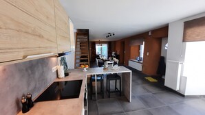 Eine moderne Küche mit einer zentralen Kochinsel, Holzschränken und einem Essbereich mit Ausblick.