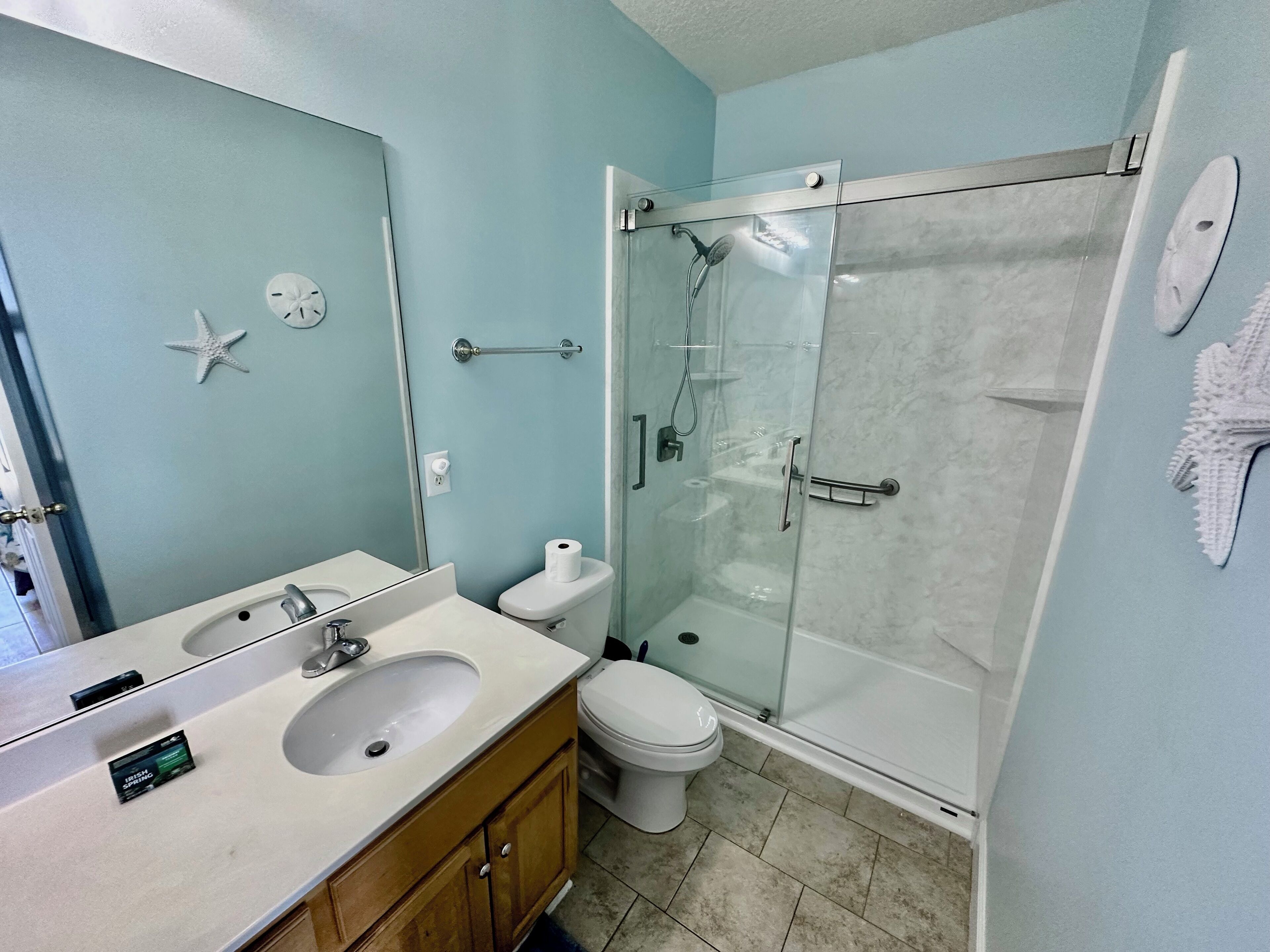 A bathroom with a sink, toilet, and glass-enclosed shower.