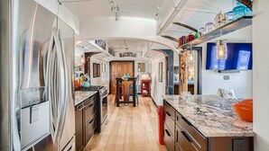Una cocina moderna con electrodomésticos de acero inoxidable, suelo de madera e isla central.
