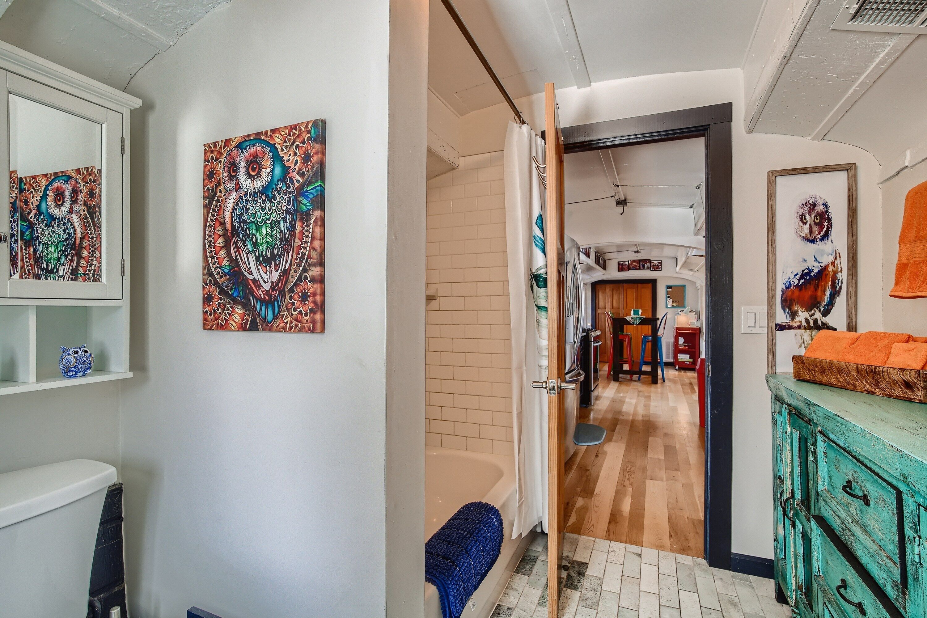 Un couloir donnant accès à une salle de bain, un coin repas et un espace de vie.