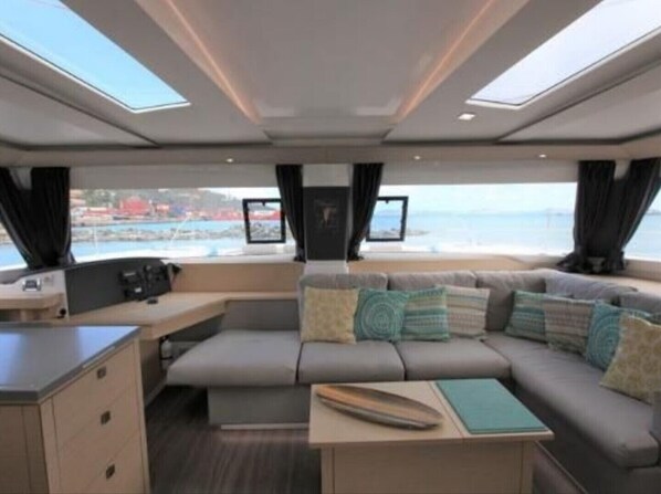 A modern interior with a sofa, a small table, and a view of the sea.