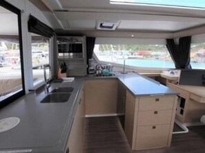Enjoy cooking in this compact kitchenette with a stainless steel sink, countertop, and storage unit.