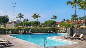 A swimming pool with lounge chairs and palm trees. - KKSR#8101 GORGEOUS 2 BEDR, GROUND FLOOR CORNER, REMODELED, AIR CONDITIONING (Kailua Kona)