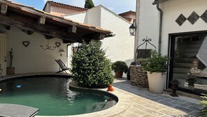 A courtyard with a swimming pool, potted plants, a wooden bench, and a stone wall. - Aix en Provence has quiet house 5m from the city center on foot (Aix-en-Provence)