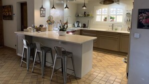 A modern kitchen with a central island, bar stools, pendant lighting, and a view of the dining area. - Aix en Provence has quiet house 5m from the city center on foot (Aix-en-Provence)