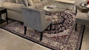 Una sala de estar con sofá, sillón, mesa de centro y televisor de pantalla plana.