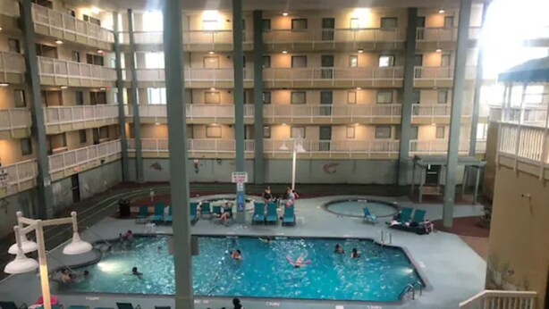Una piscina interior con varios niveles de balcones y zonas de descanso.