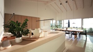 A spacious kitchen with a large island, wooden cabinets, and a view to the dining area. - Stunning new villa with beautiful lake view (Bardolino)