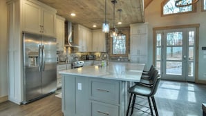 A spacious kitchen with a large island, stainless steel appliances, and a rustic ceiling. - 4 Dancing Bears|Mtn Views+Hot Tub+ Design (Blue Ridge)